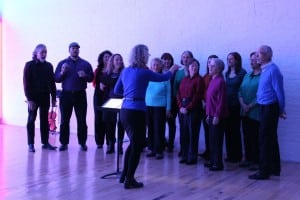 The hues from Dan Flavin's "monuments" installation at Dia gave the Beacon Music Factory's People's Choir, led by Cat Guthrie, a bathed-in-pink glow. (Photo by A. Rooney)
