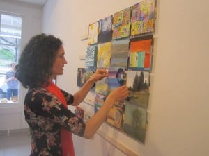 Artist Bettina Utz adds her contribution to the "mosaic" assemblage at Garrison Art Center prior to the mini-benefit last week.