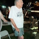 A stoic Dan Wright watches firefighters attacking the blaze in his home. Photo by L.S. Armstrong