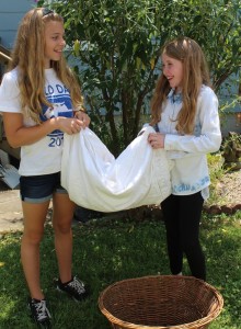 Emerson Smith, left, and May Columb, portraying two of Tevye's daughters, fold a tablecloth "in preparation for Sabbath" during a Fiddler Jr. rehearsal. Photo by Linda Speziale