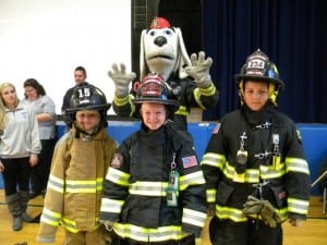 From left, Mairead O’Hara, Matthew Junjulas, and Will Etta suit up in firefighting gear.