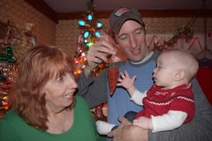 Eleven-month-old Shaylee Hamel, with her father Bob Hamel and her grandmother Carol Hamel, already seems fascinated by "the carrot." (Photo by M. Turton)