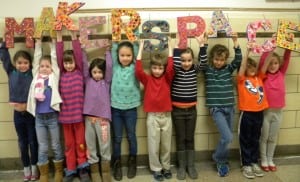 A group of Haldane second graders proudly holds the Makerspace sign.