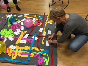 A participant adds her expression of words through objects and use of space at the DIA presentation at Howland Library.  (Photo by A. Rooney) 