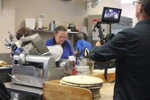 Rudy von Dommele, adjusting camera equipment trained upon the Haldane cafeteria, during the documentary production workshop. (Photo by Katie Bissinger)