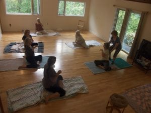 Mary Newell, standing, making an adjustment on a participant in her Feldenkrais group at her Garrison studio.  (Photo provided)