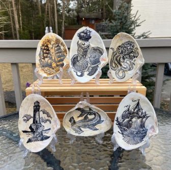 Ink illustrations on seashells, meant to resemble scrimshaw 