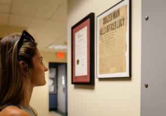 A descendant of Officer Lucy reads a 1922 news clipping at the Beacon Police Department about his death. Photo by Valerie Shively