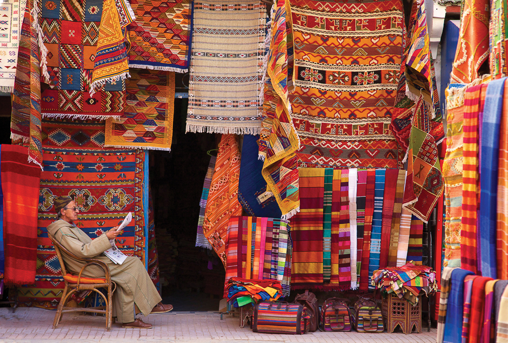 A photo by Jon Arnold of a carpet shop in Essaouira, Morocco, is accompanied in Why We Travel by a quote from Joyce Meyer: “Patience is not the ability to wait, but the ability to keep a good attitude while waiting.”