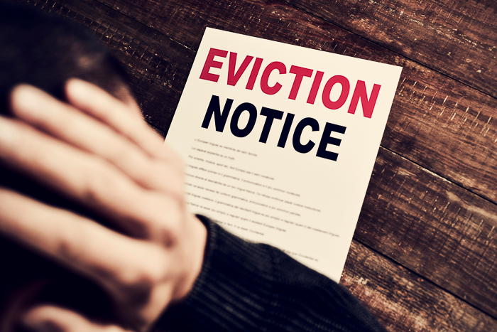 a young caucasian man with his hands in his head concerned because has just received an eviction notice
