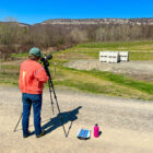 Penny Adler-Colvin of the Mohonk Preserve trains volunteers to observe peregrine falcons nesting on the ridgeline in the distance. Photo by B. Cronin