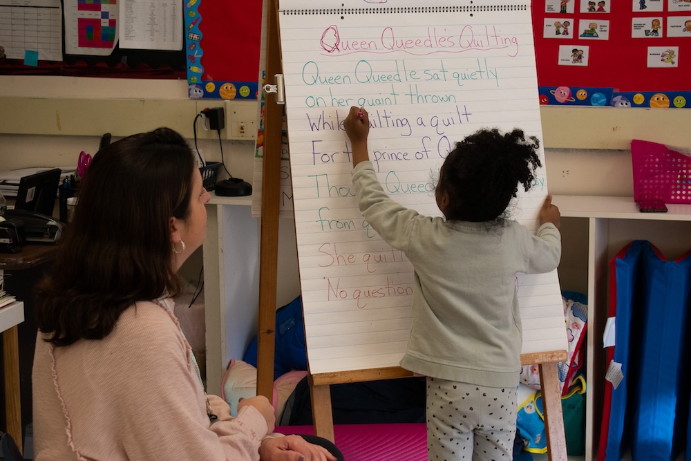 Tara English observes as a pre-K student identifies and circles a Q in a classroom exercise.