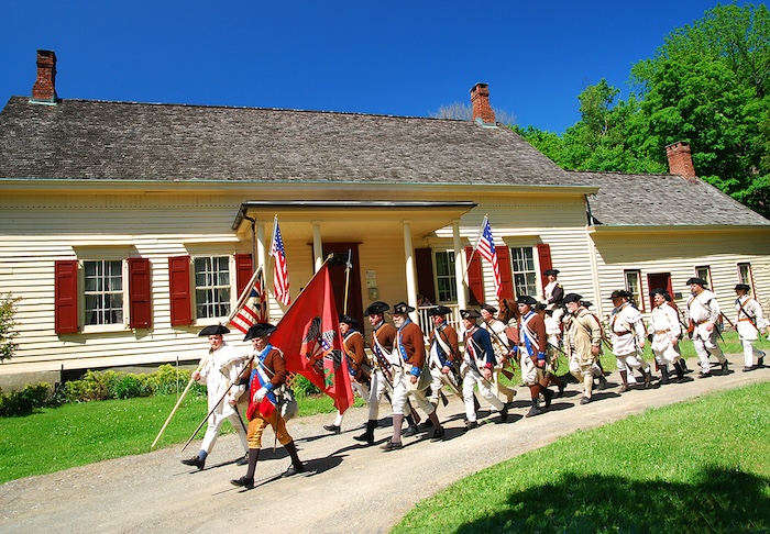 Re-enactors march past the historic site. Photo provided