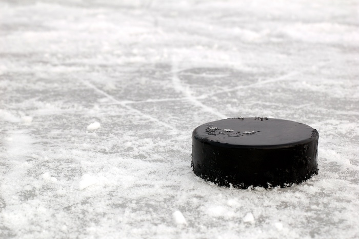 black hockey puck on ice rink