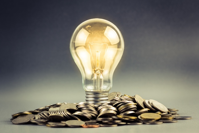 Light bulb and pile of coins energy money savings central hudson