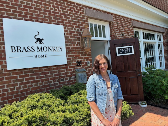 Gina Larson poses outside Brass Monkey Home, which opened in May. Photo by M. Ferris