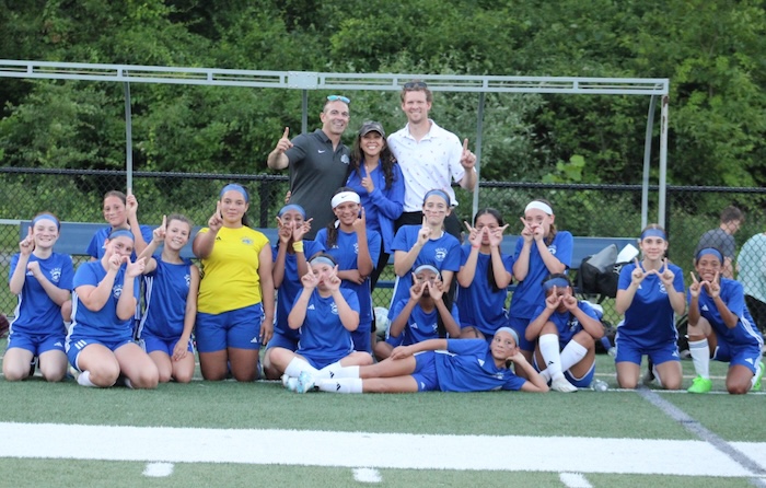 The Lady United team signals victory.