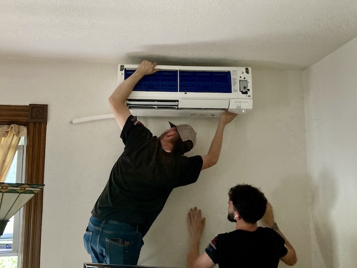 Technicians install a wall unit in our living room. Photo by J. Simms