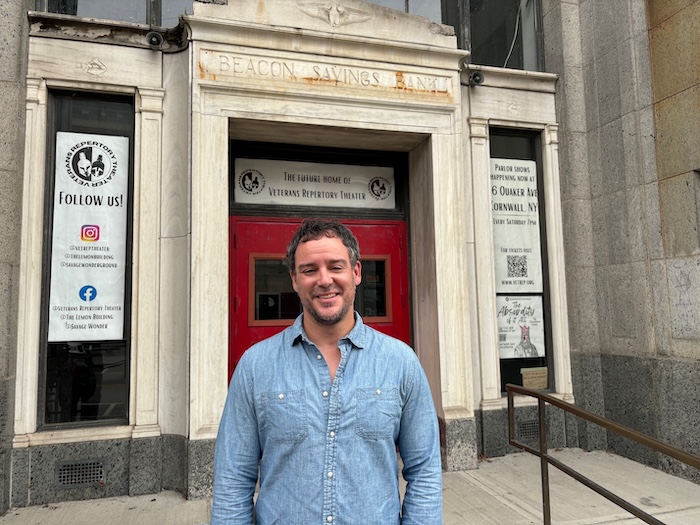 Chris Meyer, the founder and artistic director of VetRep, stands outside its new home in the former Beacon Savings Bank building. Photo by M. Ferris