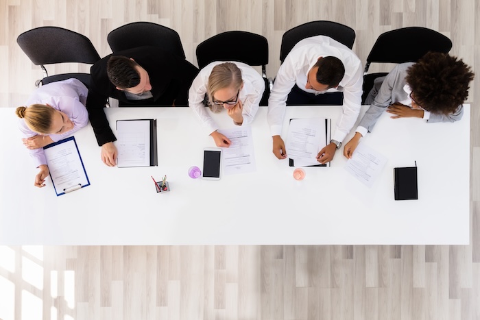 Panel Of Corporate Personnel Officers Sitting At A Table